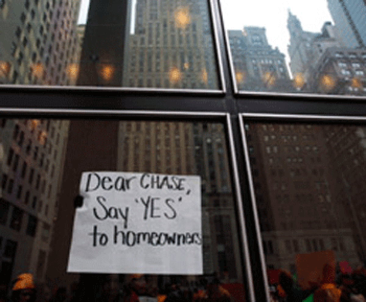 Protesters organized by the Neighborhood Assistance Corporation of America display a sign from inside the lobby of the One Chase Manhattan Plaza building on Dec. 14, 2009, in New York City. (Chris Hondros/Getty Images)