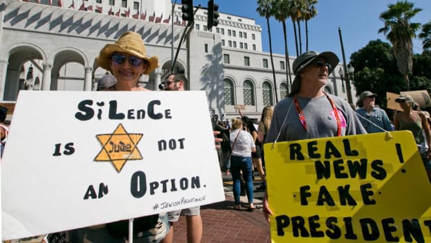 Helen Rubenstein, left, holds a sign Sunday, Aug. 13, in downtown Los Angeles. She said her parents were Holocaust survivors, and she's worried that extremist views were becoming normal under Donald Trump's presidency. The image on her sign is the Jewish star that Nazis required all Jews to wear "sewn firmly on their clothing." | Damian Dovarganes / AP