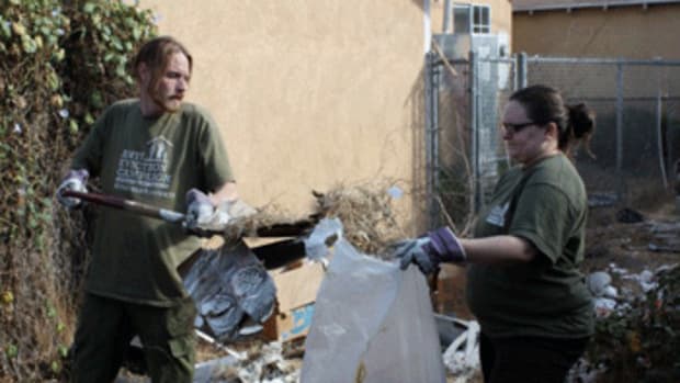 Adam Rice, co-chair of the Los Angeles Anti-Eviction Campaign, and organizer Callie Little, pick up trash in a South LA alley. Their goal, along with residents, is to clean the alley and hopefully turn it into a garden or place where children can play.