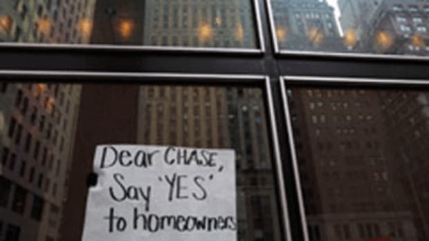 Protesters organized by the Neighborhood Assistance Corporation of America display a sign from inside the lobby of the One Chase Manhattan Plaza building on Dec. 14, 2009, in New York City. (Chris Hondros/Getty Images)