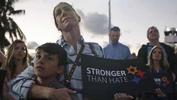 Taly Kogon and her son Leo, 10, listen to speakers during an interfaith vigil against anti-Semitism and hate at the Holocaust Memorial late last month in Miami Beach, FL Wilfredo Lee/AP