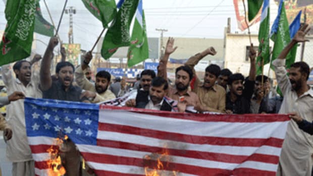 Pakistanis burn an American flag in protest of NATO border strike. AFP PHOTO/ S.S. MIRZA