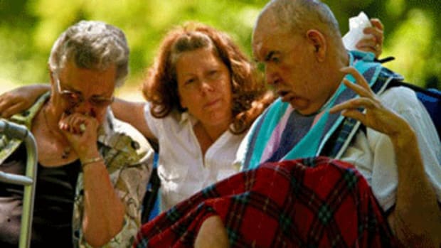 Mother Dorothy Turpen (left) and caregiver Bev Glasgow sit next to Reggie Lane during a memorial service for his wife, Linda, in July 2009. Linda had been hospitalized after suffering respiratory distress. Under the shade of scrub oak and aspen, Reggie watched as Linda’s family and friends sang 'Amazing Grace' and looked at old photos of the couple. (Francine Orr / Los Angeles Times)