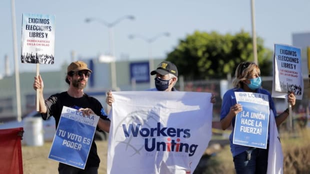Activists hold a protest outside the General Motors' pickup truck plant as workers vote to elect a new union under a labor reform that underpins a new trade deal with Canada and the United States, in Silao, Mexico February 1, 2022. (REUTERS/Sergio Maldonado)