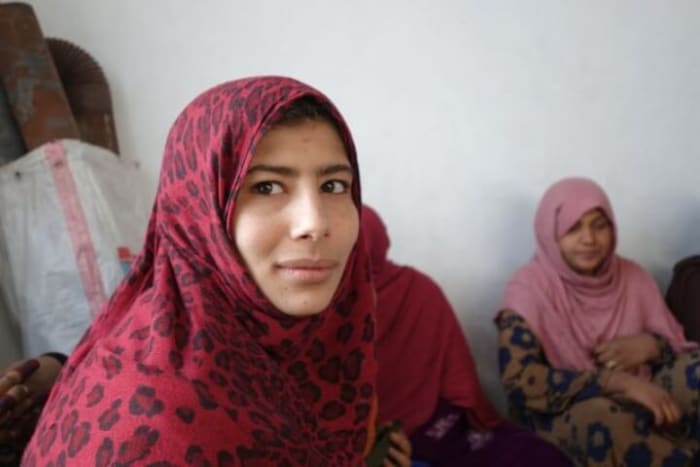 Ramzia, an IDP from Laghman province, works in the JRS kindergarten in “Police” refugee camp while two of her brothers are paid by a shopkeeper to pack potatoes into sacks.