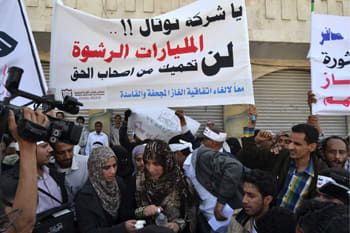 “Hey, Total! Your billions will not protect you!” reads a sign. Demonstrators have called for the cancellation of unfair gas and oil contracts.
