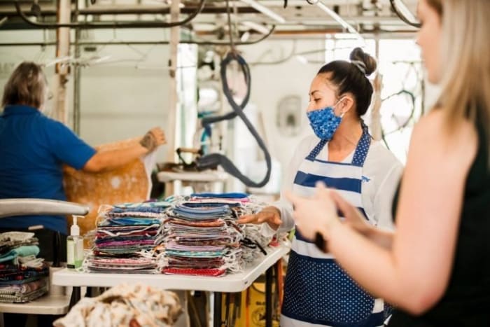 Martinizing Dry Cleaning owner Chheavy Lema, center, volunteered her shop and staff to help the group Face Mask Makers with Love. Photo by Vindy Leung.