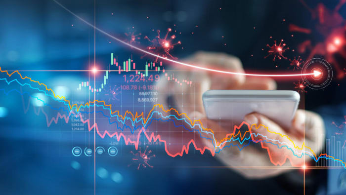 Economic crisis, Businessman using mobile smartphone analyzing sales data and economic graph chart that is falling due to the corona virus crisis, Covid-19, stock market crash caused.