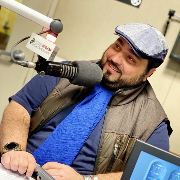 Alireza Hekmatshoar, program director at Radio Iran KIRN 670 in Los Angeles, sits at the radio microphone. (Alireza Hekmatshoar)