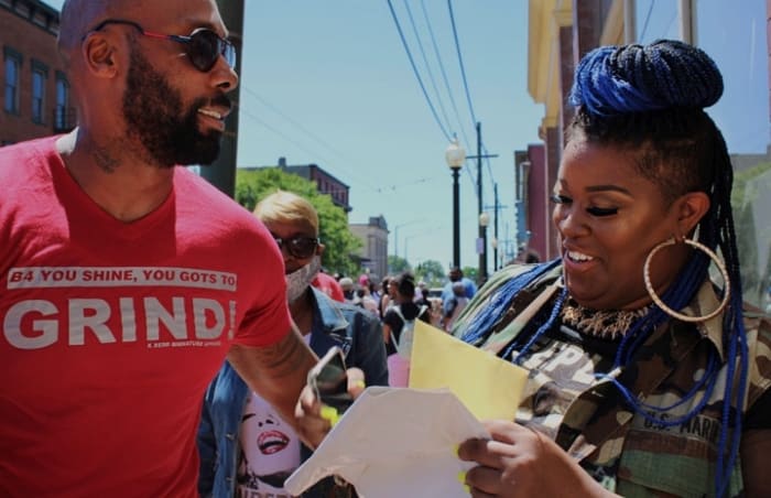Darnell Redd, owner of K. Redd Signature Apparel, greets Chanta Winston at the Entrepreneur Shoppe's opening in early June. Photo: Maki Somosot.