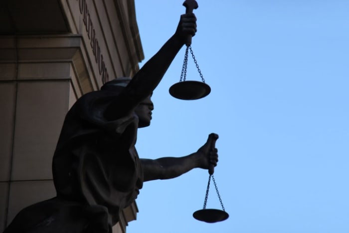 A statue of “blind justice” holds a pair of scales, on the exterior of the Albert V Bryan Federal District Courthouse in Alexandria, Virginia.