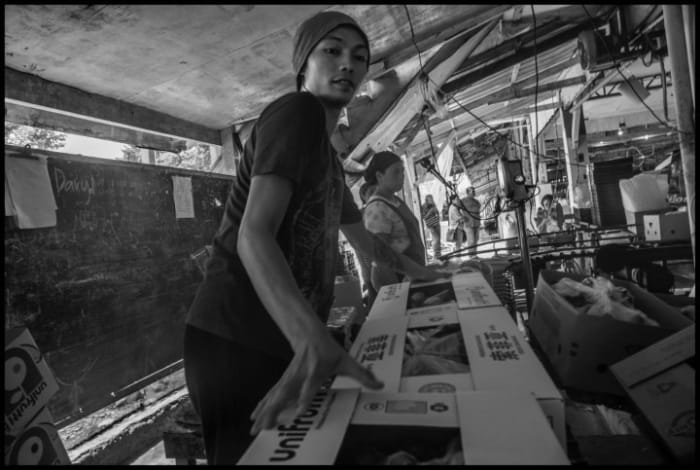 Alvee Mabong packs bananas for Unifrutti in the DARBCO packing shed. Photo copyright © 2020 by David Bacon.