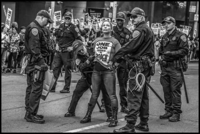 Jessica Etheridge is searched in the middle of Fourth Street outside the Downtown Marriott, as she and others were arrested in an act of civil disobedience during the Marriott strike.
