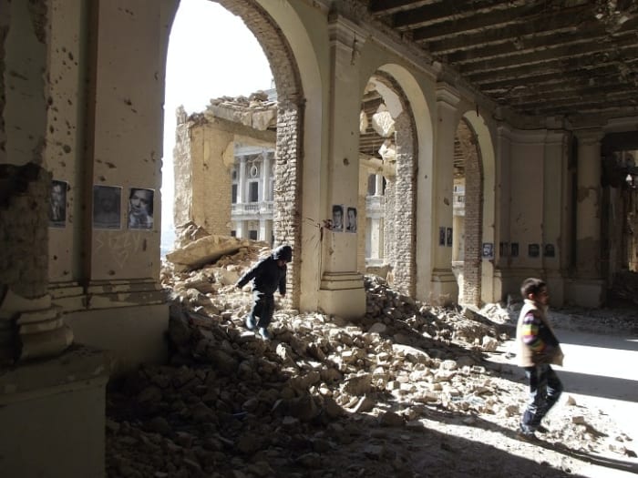 Afghan children play in the bombed out rubble of the Darul Aman Palace in Kabul, amidst a photo exhibition marking four decades of Afghans killed in war and oppression (Photo: Maya Evans)