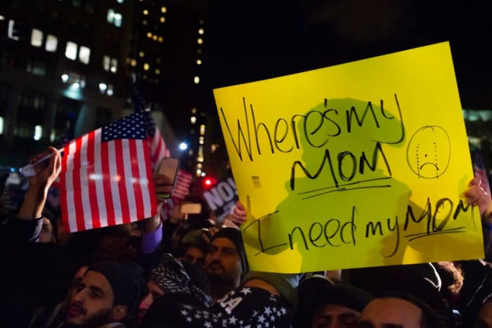 A child sits on the shoulders of his father at the Yemeni bodega strike, asking, “Where is my mom?” (Michael Nigro)