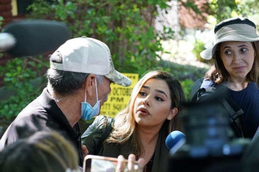 Lidia Terrazas (center), a multimedia reporter for Univision San Antonio, listens to George Rodríguez near a memorial for the shooting victims outside Robb Elementary School in Uvalde, Texas. He told her he wanted the world to see his grandson. Photo by Eleazar Rodiles