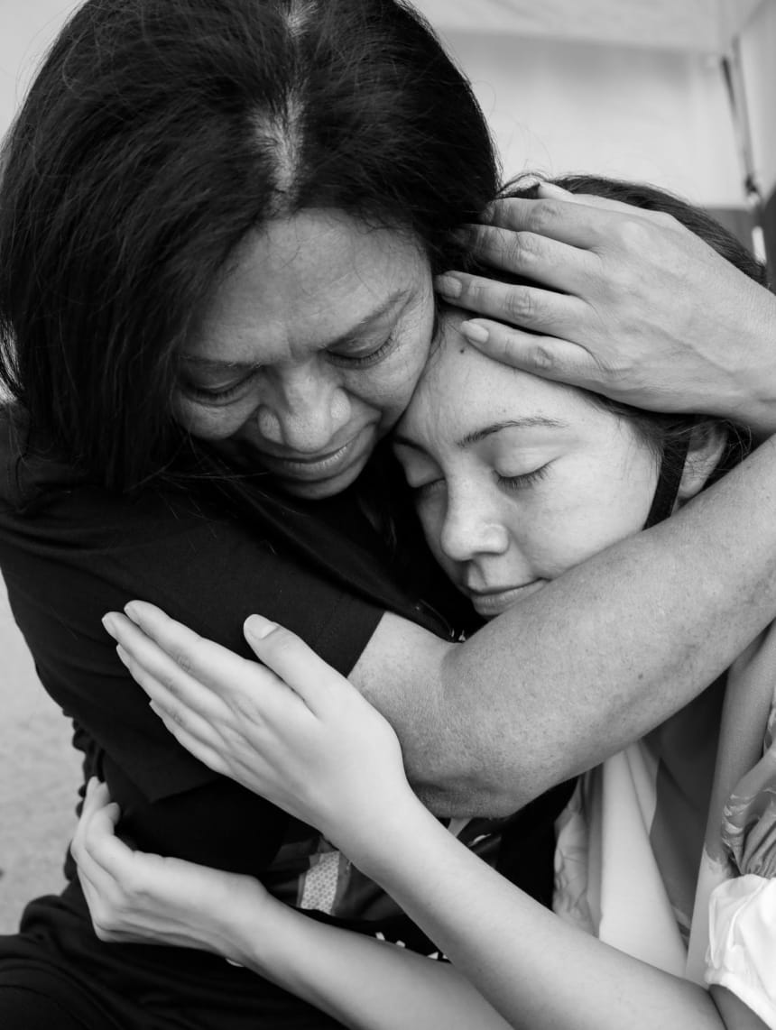 On the morning of the third day of the hunger strike, Leonor and Debbie begin to feel more and more tired. In this moment, mother and daughter sit on the sidewalk holding each other. October 4, 2020. Photo by Zaydee Sanchez for palabra