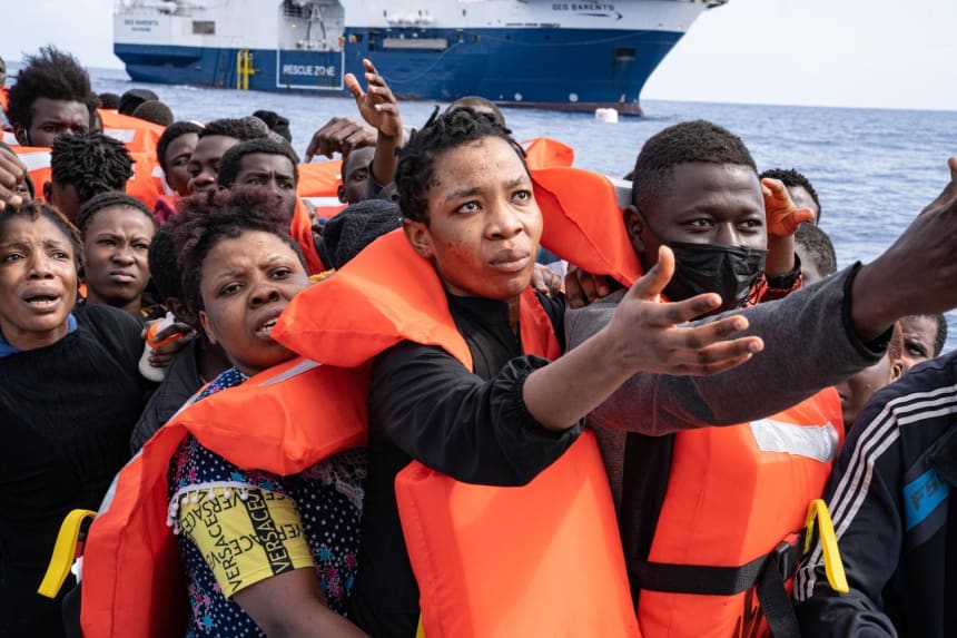 A woman pleads with rescuers to take her next as others wait to be transported to the Geo Barents, seen in the background. May 9, 2022. Photo by Lexie Harrison-Cripps for palabra