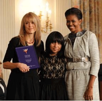 Harmony Projects founder Margaret Martin and seventh-grader Kiana Coronado-Ziadie receive an award from First Lady Michelle Obama. (Photo Credit: White House)