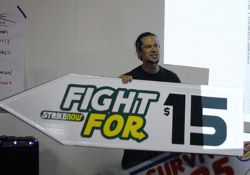 Gan Golan, Beautiful Trouble’s director of training, demonstrates a sign that could be used for the fast food workers strike. He advised activists to keep their message simple and use corporate logos and graphic arts to better communicate their cause. (Dan Bluemel / LA Activist)