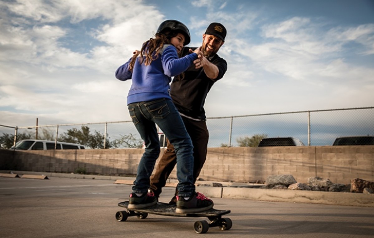 Michael Shapiro, skater, former teacher and executive director of the +swappow PLUS Foundation, works with a youth on her skateboarding skills. Photo courtesy of Michael Shapiro