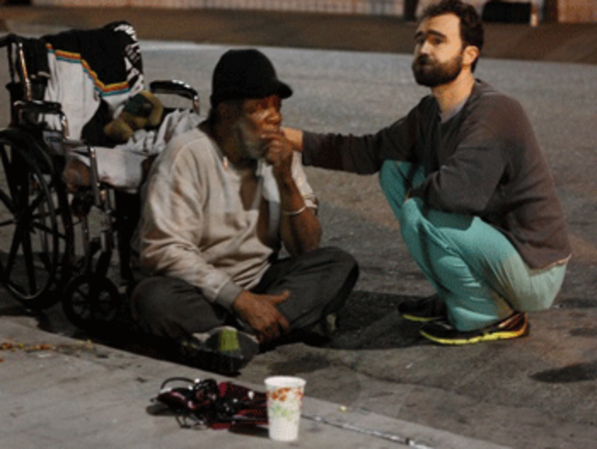 Dr. Walter Coppenrath, the UCLA Mobile Clinic’s lead physician, stays with a homeless man while waiting for paramedics to arrive. The man had been complaining of chest pains.