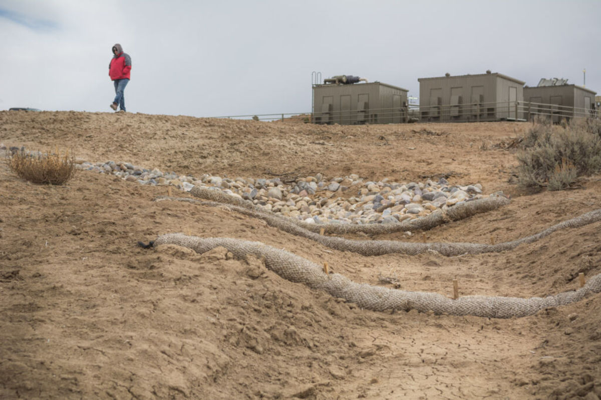 Mario Atencio walks past the wash near his grandmother's home where 1400 barrels of fracking sluury poured out in 2019. ©2021/Jerry Redfern