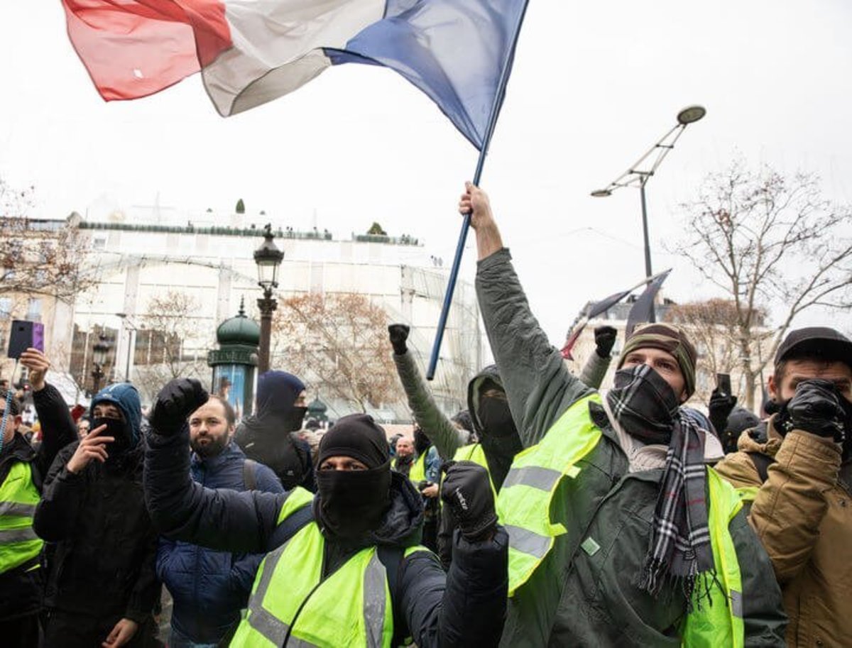 Protesters wearing yellow vests chant slogans and wave the French national flag, during the anti-government demonstrations in Paris, France, December 08, 2018.