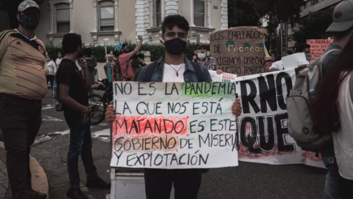 A protester in Bucaramanga holds a sign in a mobilization on October 21, 2020 that reads: “It is not the pandemic that is killing us it is this government of misery and exploitation”. Photo: Colombia Informa