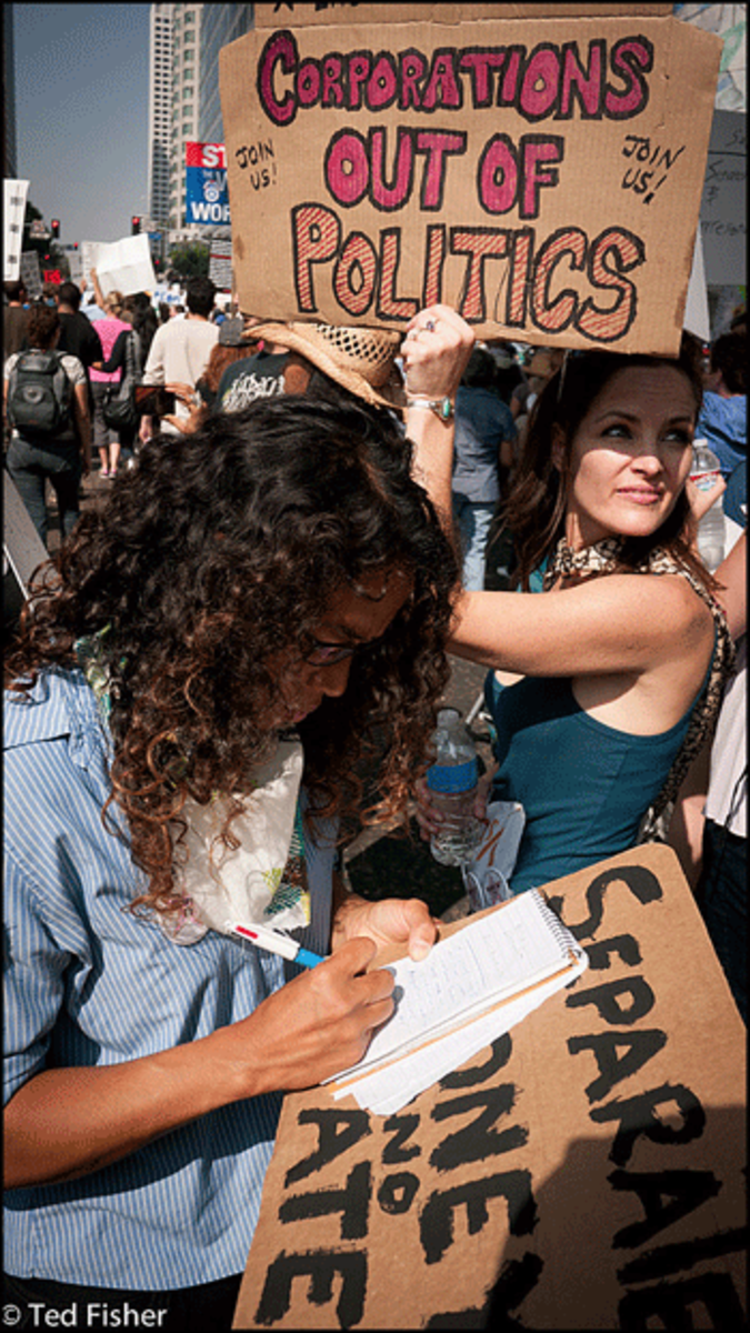Ky Primo writes a note on her view of "Occupy Los Angeles" while her friend Eddie Daniels holds a sign during the protest march in Los Angeles on Saturday, October 15, 2011. The note read "Let us educate ourselves, help educate others on how banks, taxation and trade work. Use the energy to amend the Constitution to separate money and state. Yes we can." (Photo: Ted Fisher)