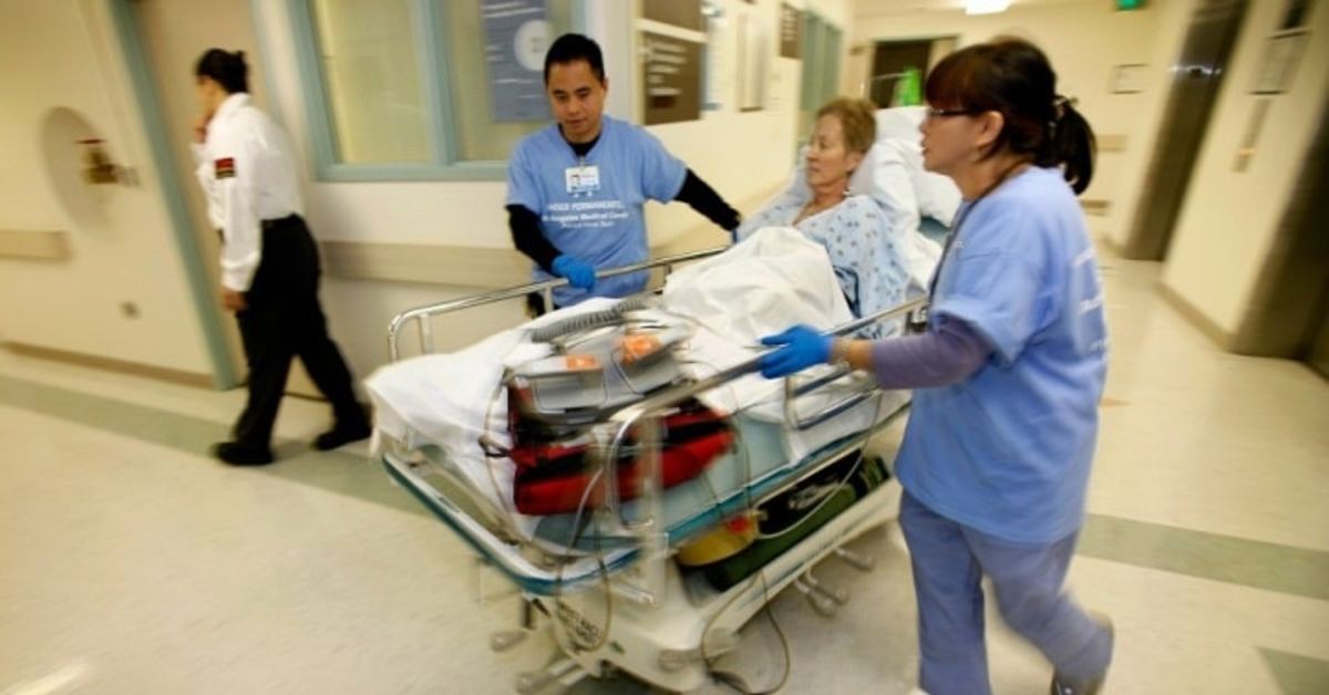 Patient Karen Ballog, 57 years old, is moved from her room in the cardiac care unit through the halls of the old Los Angeles Medical Center by nurses Jojo De Guzman (left) and Elmir Lutz (right) to the new part of the Medical Center. (Photo: Al Seib/Los Angeles Times via Getty Images)