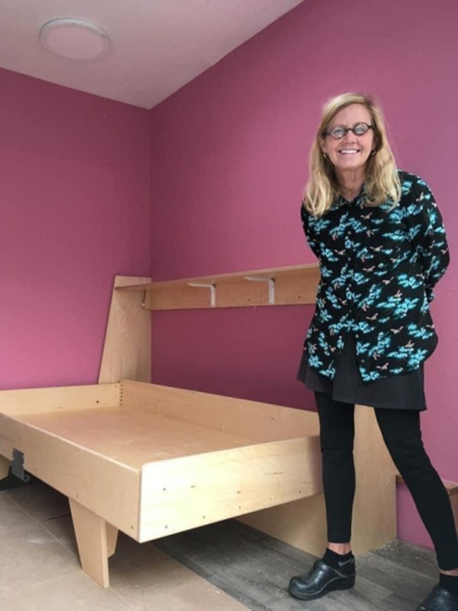 YSA founder Sally Hindeman poses with one of the custom Murphy beds featured in the tiny homes. Photo courtesy of Youth Spirit Artworks