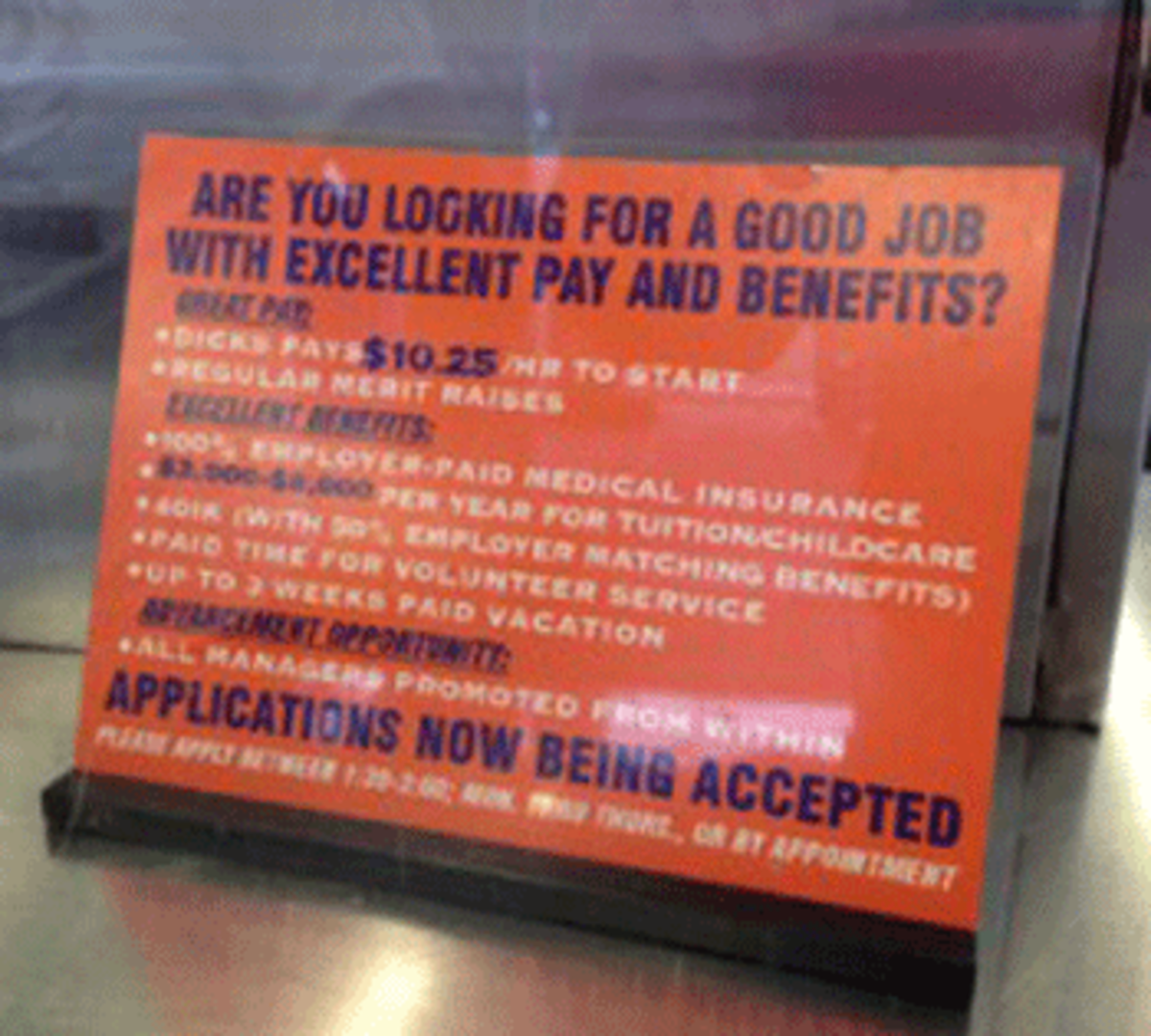 A sign at Dick’s Drive-In in Seattle outlines the hourly wage of at least $10 and medical and dental benefits offered to its employees.