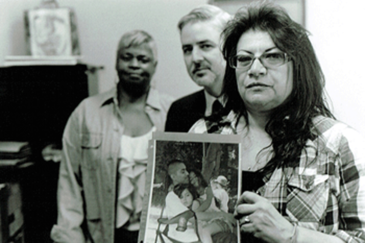 Blanca Bosquez holds a picture of her son while at a meeting with her son’s public defender, Ross McMahon, and De-Bug organizer, Gail Noble. They are fighting to bring Blanca’s son, Danny, home to be a father to his new child. If convicted, Danny could serve years in prison. (Photo: Charisse Domingo)