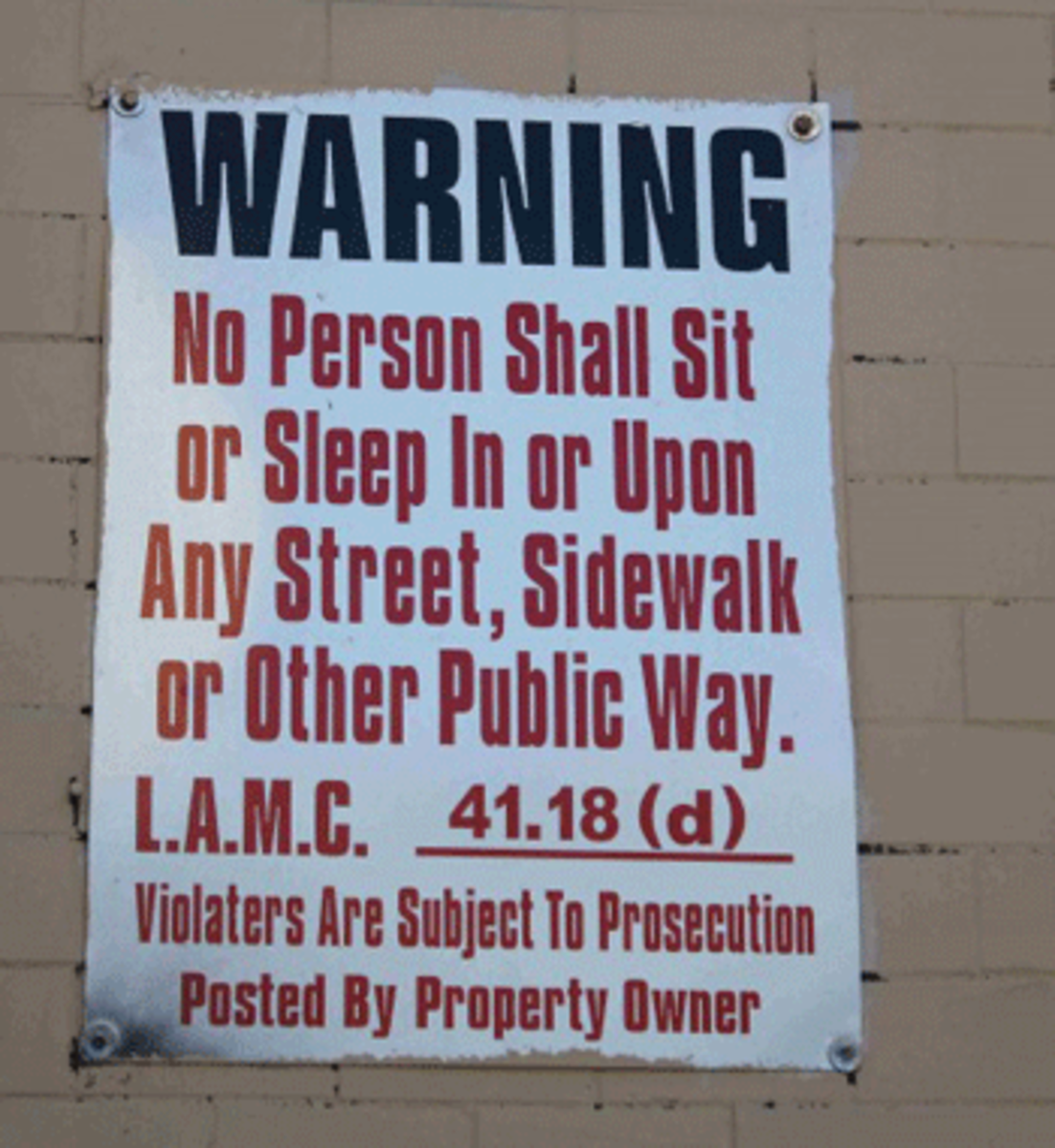 A sign posted on a building in Skid Row hangs as a constant reminder of an LA municipal code that critics say discriminates against the homeless. (Dan Bluemel / LA Activist)
