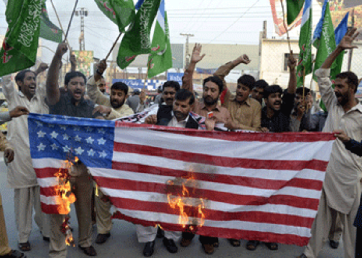Pakistanis burn an American flag in protest of NATO border strike. AFP PHOTO/ S.S. MIRZA