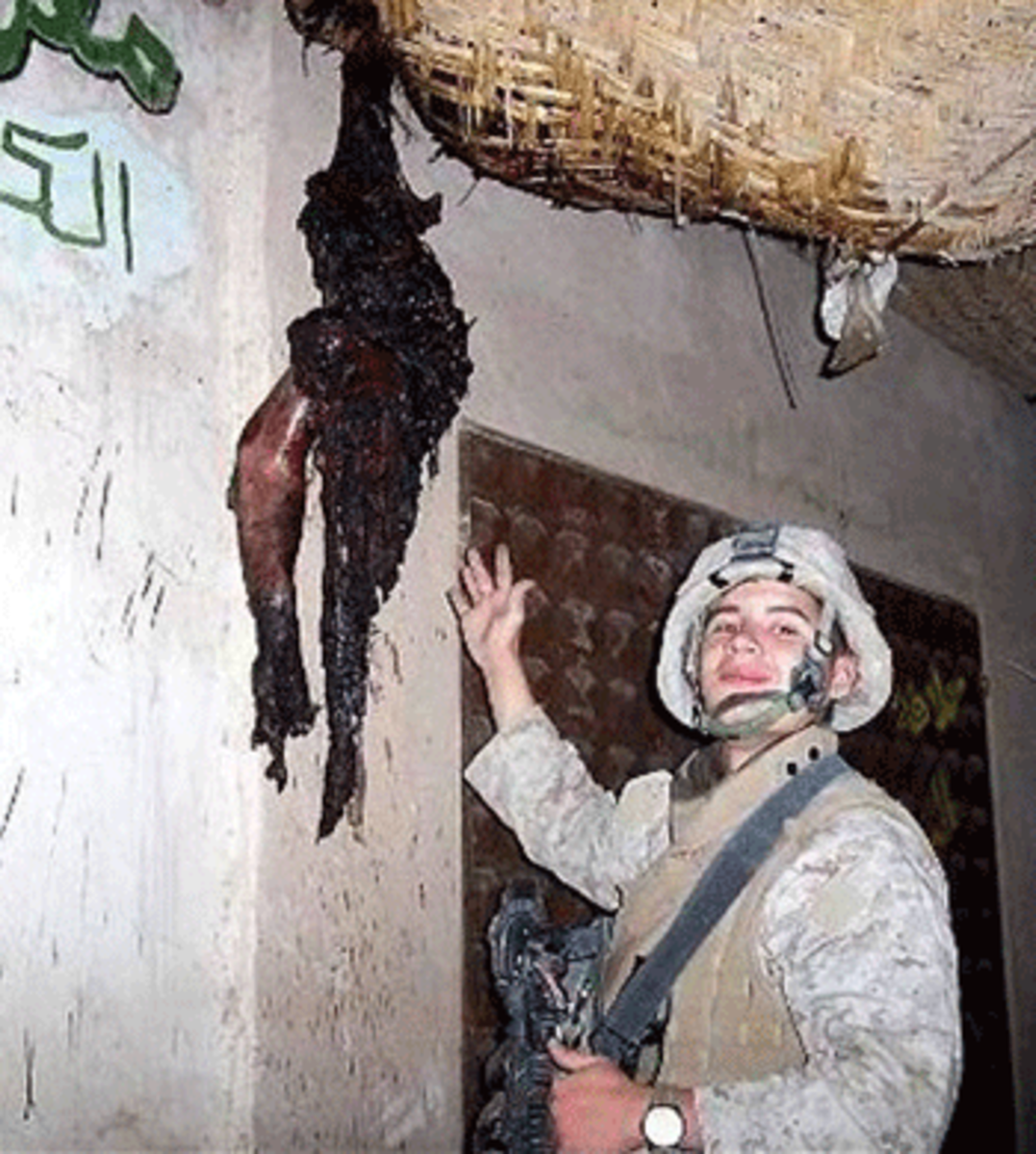 American Soldier showing a severed Iraqi arm hung in a mosque to terrorize the Iraqi resistance.