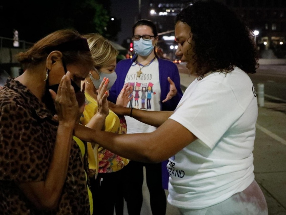 Jael Altamarino (front right) leads a pre-dawn prayer, outside the Federal Building in downtown Los Angeles, for Ana Arellano (front left) and mothers and wives of Adelanto detainees. Photo by Zaydee Sanchez