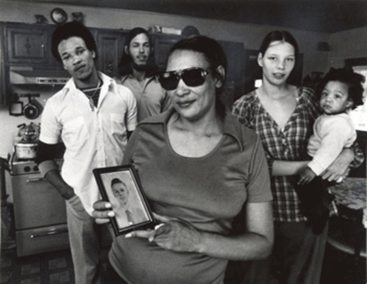 Mildred Loving holds a photo of her husband Richard as a young man. The Lovings were codefendants in the 1967 U.S. Supreme Court case that overturned state bans on interracial marriage. The Lovings' children stand in the background: