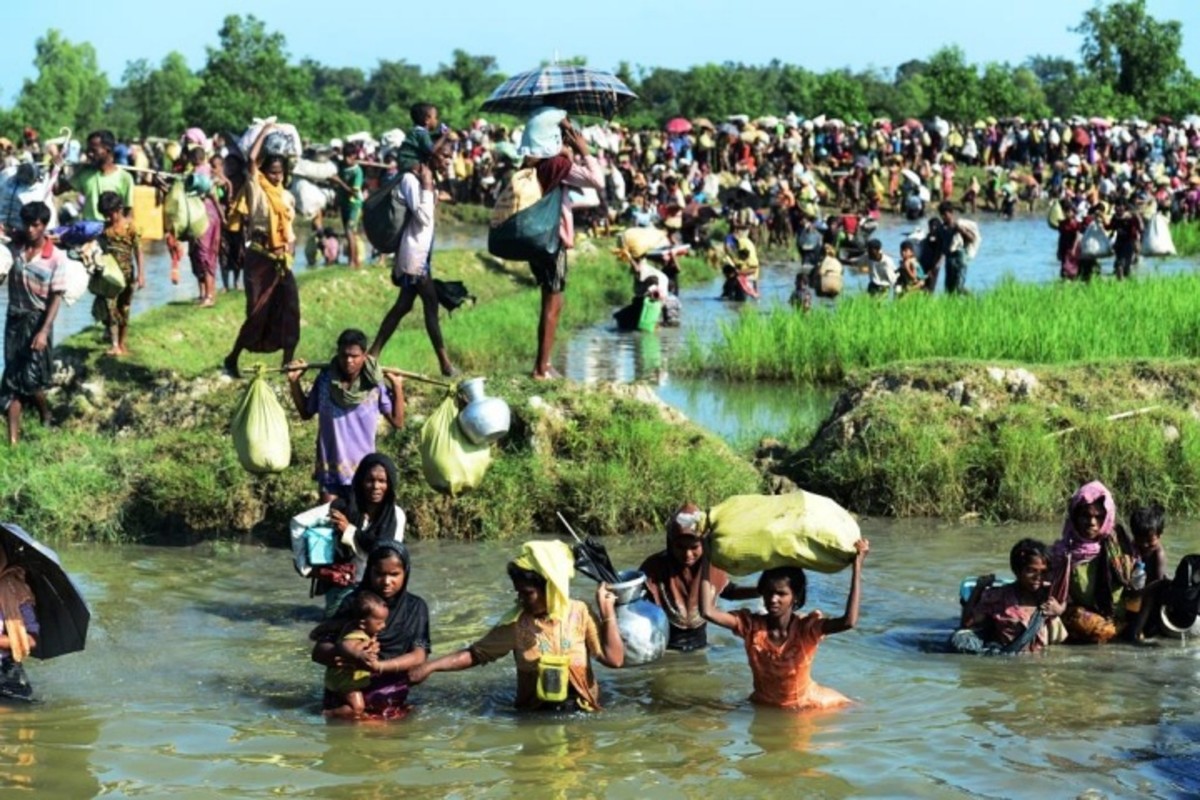 Rohingya refugees walk through a shallow canal after crossing the Naf River, in Palongkhali near Ukhia, as they flee violence, in Myanmar to reach Bangladesh. AFP