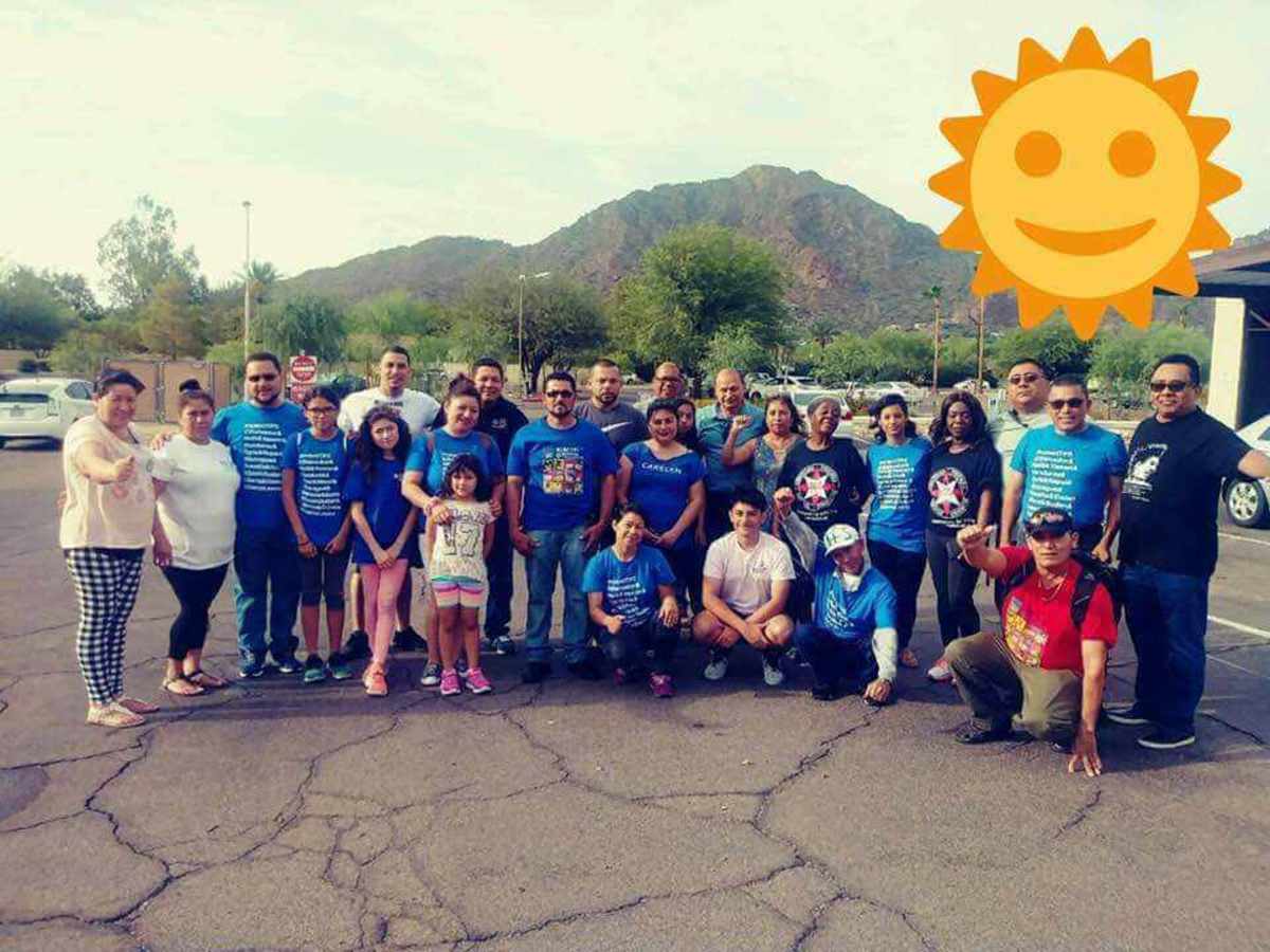 Evelyn, center, standing in the blue CARECEN shirt behind the person kneeling, in Phoenix with other Journey for Justice participants.