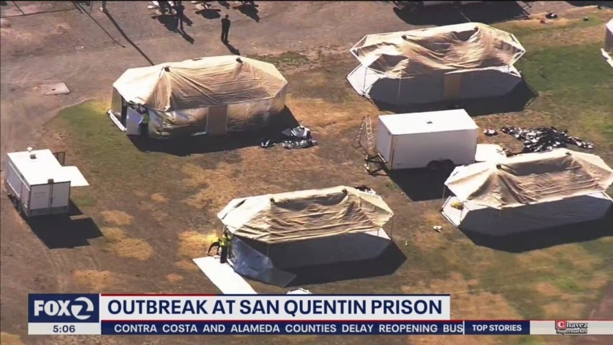 Television news aerial shot of temporary camps set up on the San Quentin state prison grounds, after an outbreak of COVID-19.