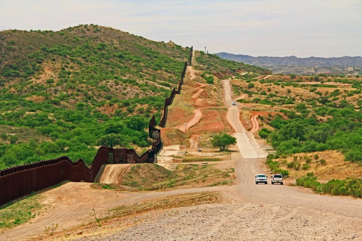 Border fence alongside a road near Nogales, Arizona. Photo via Shutterstock
