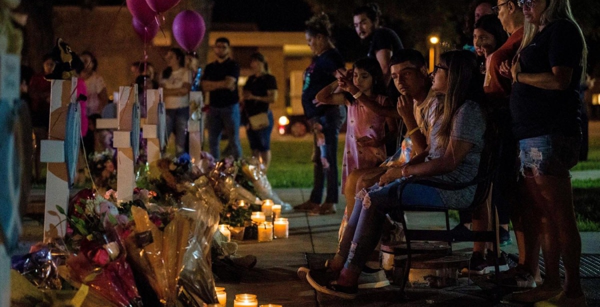 Community members leave flowers, candles, stuffed animals and balloons and grieve in front of cross memorials for victims of the Ross Elementary School massacre, at the town square in Uvalde, Texas, May 26, 2022. Photo by Jintak Han/ZUMA Press Wire via Alamy