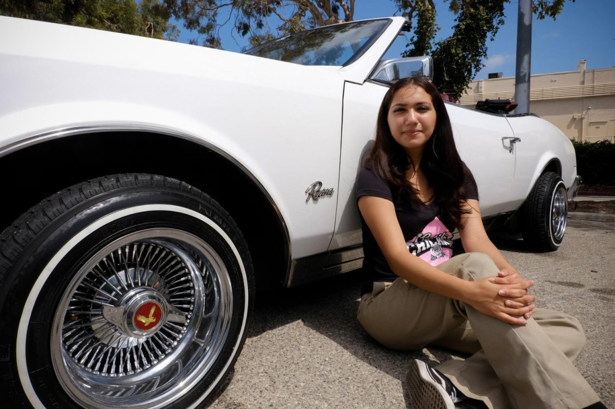 At the women's lowrider meet-up in San Pedro, California, Julissa Munoz shows off her '85 Buick Riviera. Munoz, a high school senior says, "It's inspiring to see that our culture has not died. It brings me so much joy." Photo by Zaydee Sanchez for palabra