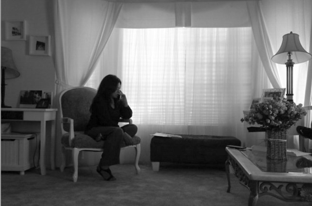Inside her living room, Leonor speaks to Hugo on the phone from Adelanto Detention Center. Since Hugo has been detained, the couple speaks at least twice a day. April 8, 2021. Photo by Zaydee Sanchez for palabra