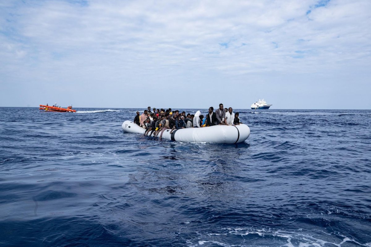 Over 100 people on a smugglers’ boat wait to be rescued and transferred to safety. The Geo Barents search-and-rescue ship and a fast response boat are seen in the background. May 9, 2022. Photo by Lexie Harrison-Cripps for palabra 