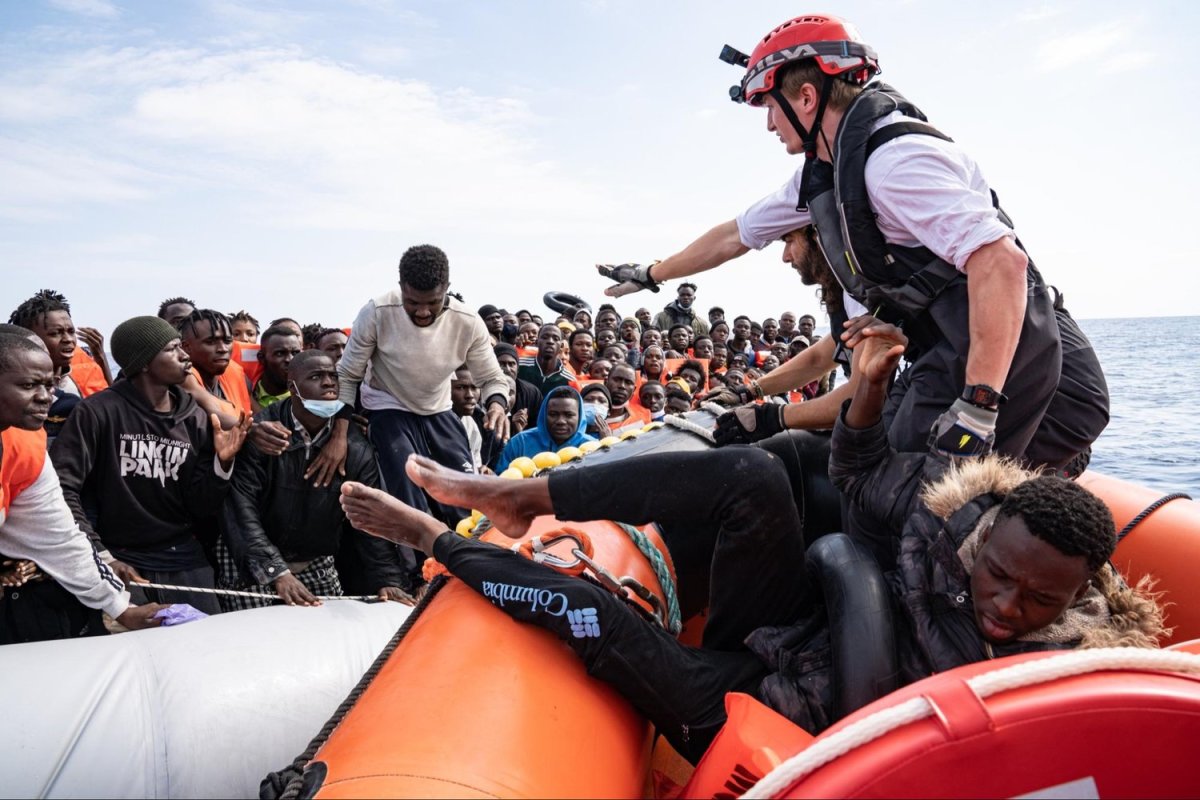 In the Mediterranean Sea, a Doctors Without Borders search-and-rescue team transfers migrants from a crowded smugglers’ boat onto a rescue boat. Next, they are transported to the Geo Barents ship. May 9, 2022. Photo by Lexie Harrison-Cripps for palabra